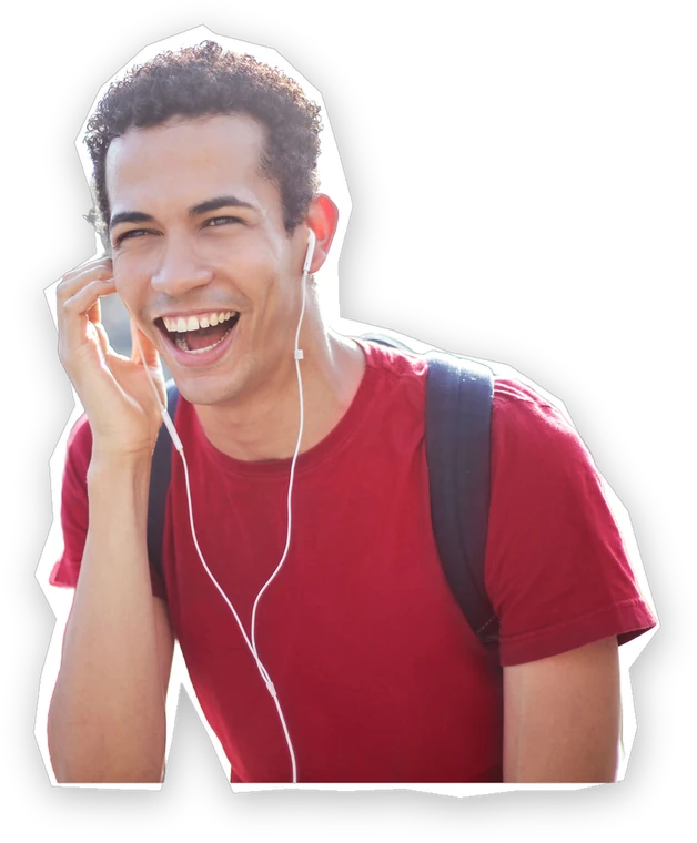 A young man laughing on the phone, out on the street